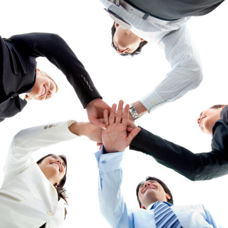 Business team with their hands together in the middle isolated over white